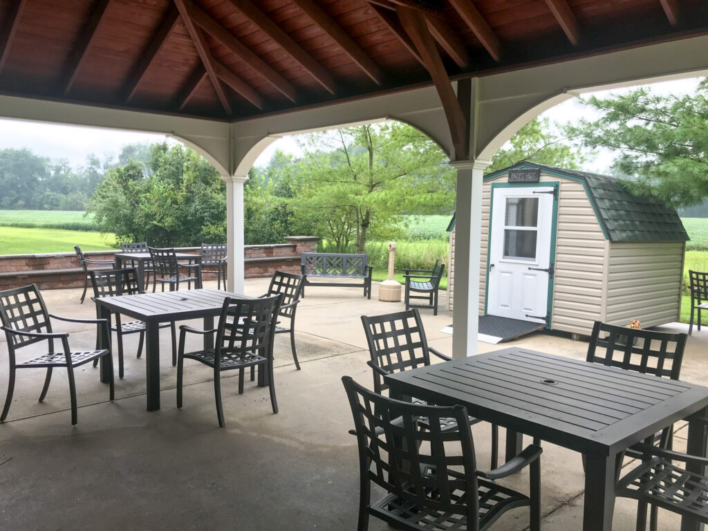 The Homestead at Harmony back patio has tables and chairs for residents. 