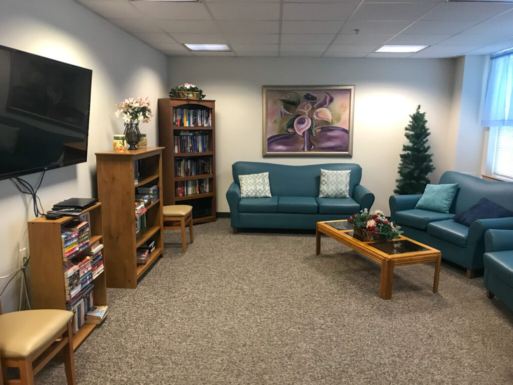 The Homestead at Harmony recreation room is fully furnished with books, games, a TV and furniture. 